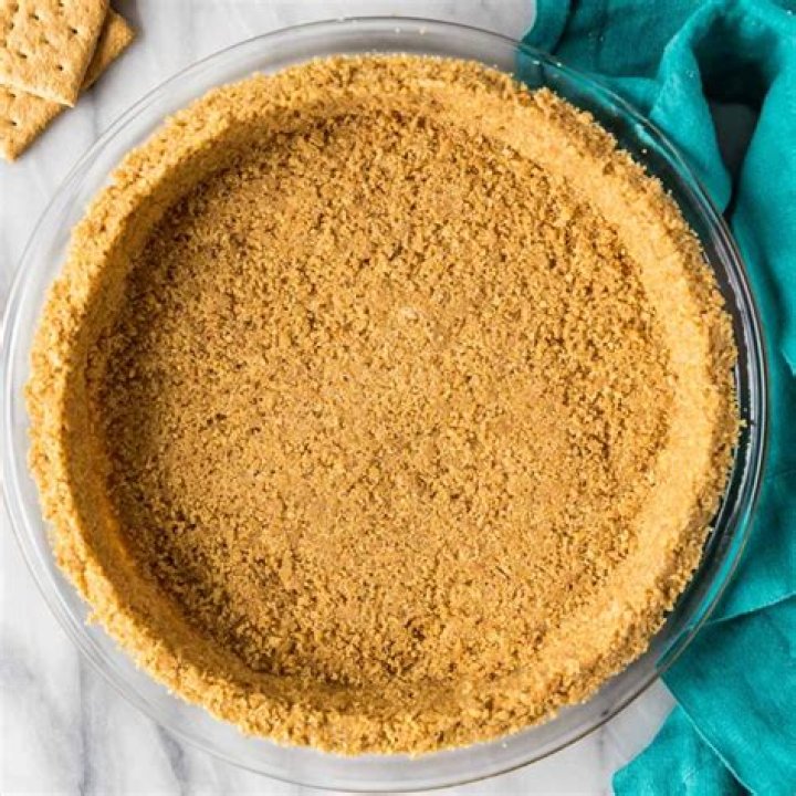 Graham cracker crust in a glass bowl and in a muffin pan.